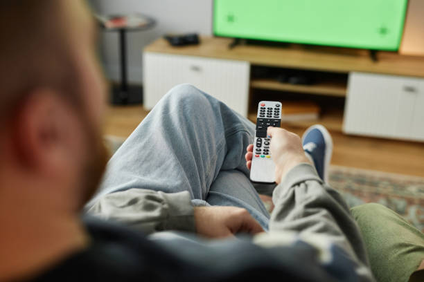istock Man Watching TV Hand Holding Remote 2191783804