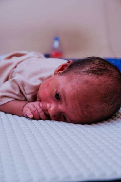 istock Newborn baby 2 month laying on stomach developing neck control on mattress bed. tummy time for strengthen baby neck and shoulder muscles 2191786821