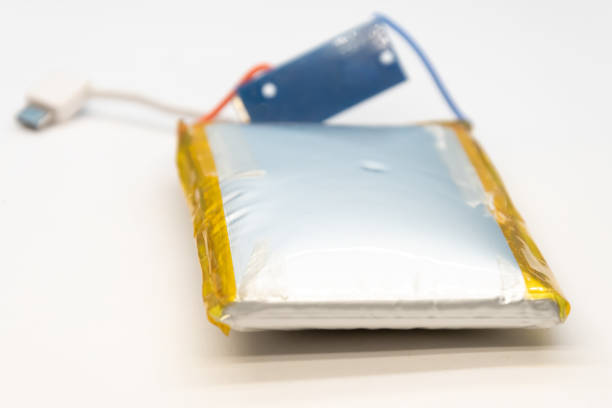 Portable ruined and bloated battery on white background.