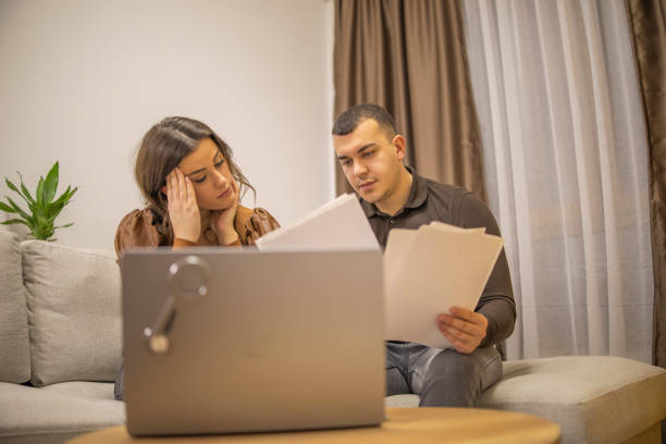 istock Young couple doing paperwork, thinking about the financial problems, and making savings plan at home. 2191792042