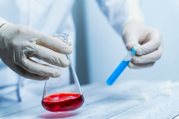 istock Scientist handling flask with red liquid and blue test tube 2191793776
