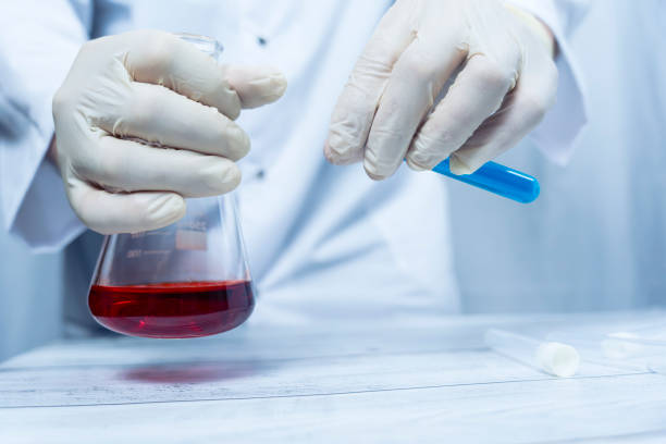 istock Scientist handling flask with red liquid and blue test tube 2191793777