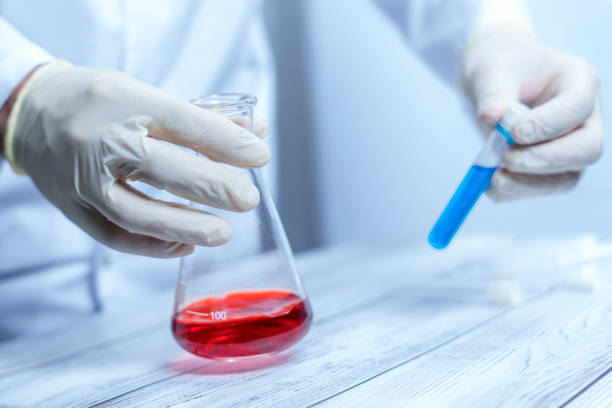 istock Scientist handling flask with red liquid and blue test tube 2191793780