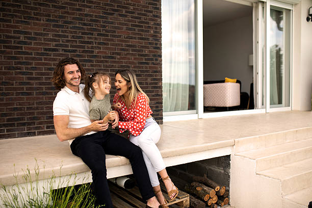 Young parents having fun with their daughter at the house back yard