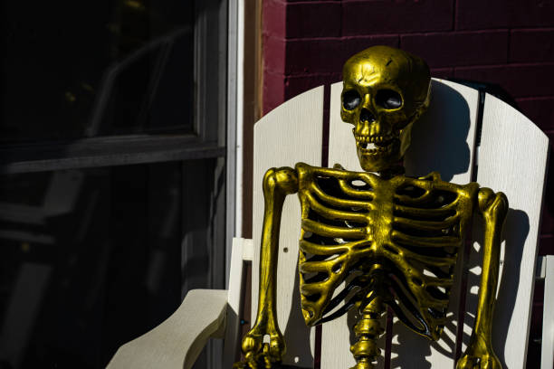 A funny Halloween skeleton looking excited and waving it's boney hand.