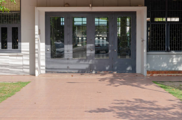Long corridor under a building with peach color walls and row of doors.