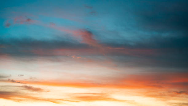 istock Romantic sunset scene featuring a gradient of warm peach and orange hues blending into a rich, deep blue sky 2191805438