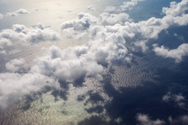 Beautiful, dramatic a group of clouds in the sky over the ocean viewed from a height from inside an airplane.