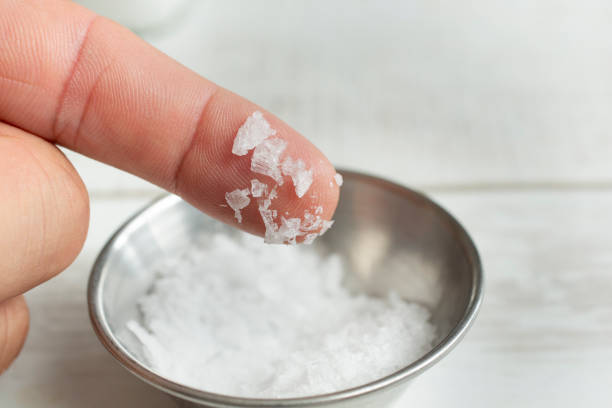 A view of large sea salt crystals on the tip of a finger.