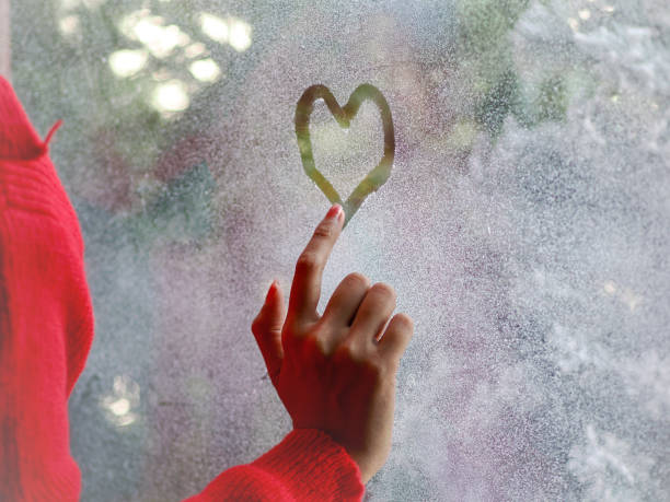 istock Hand draws love heart on cold fogged window background, closeup image 2191816154