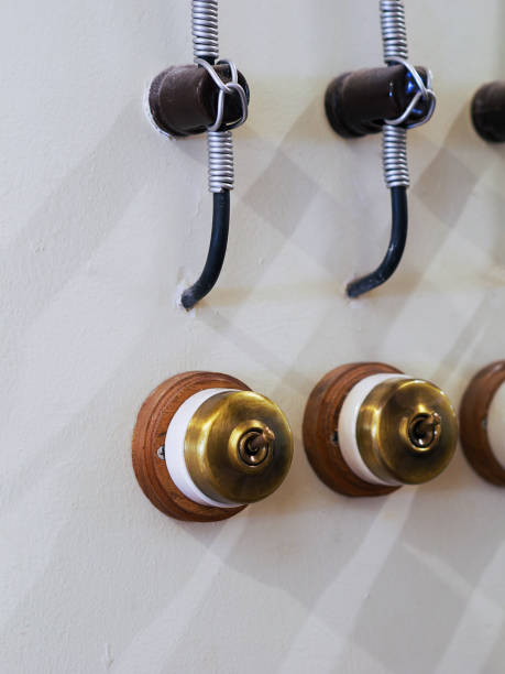 istock Retro style brass power switches on white wall. Brass vintage switch on interior wall. 2191816156