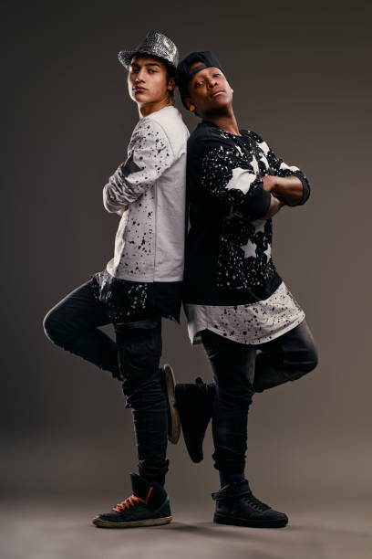 istock Two young male dancers with arms crossed posing back to back 2191816451