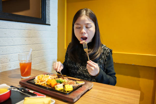 istock Asian woman eating steak in restaurant 2191816654