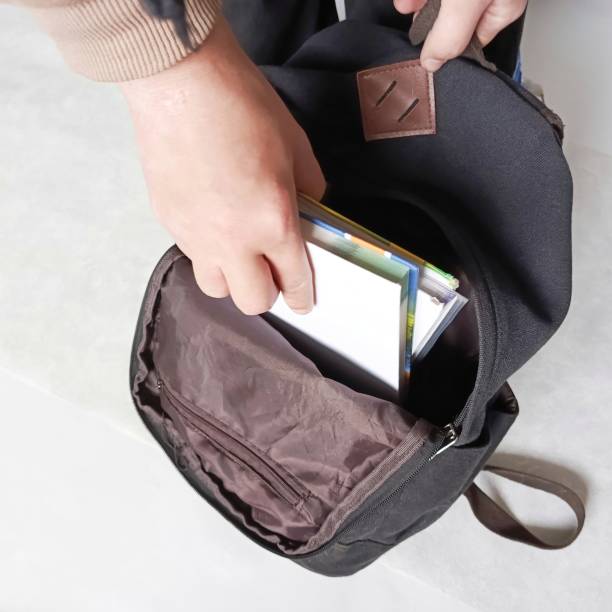istock The student's hand puts books in a backpack. The school library. A student collects a briefcase. Educational literature. 2191819716