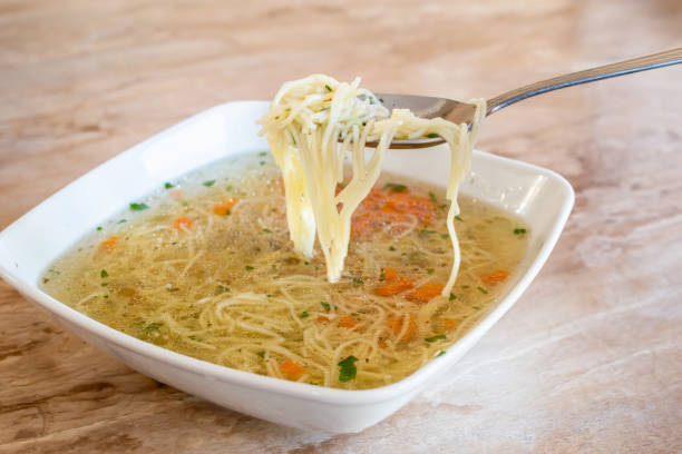 broth with noodles, decorated with parsley and carrots