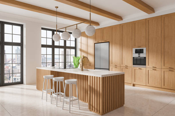 istock Modern kitchen interior with light wood cabinets, large island counter, and stools, featuring large windows and city view in home design. 3D Rendering 2191824481