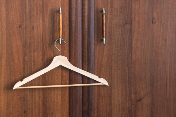 Wooden hanger for clothes on the cabinet handle.