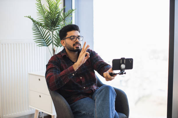 istock Indian man creating content with smartphone indoors 2191828167