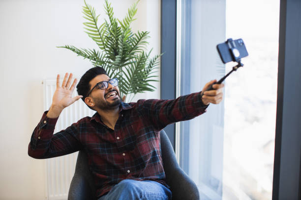 istock Smiling man taking selfie with smartphone in casual setting 2191828170