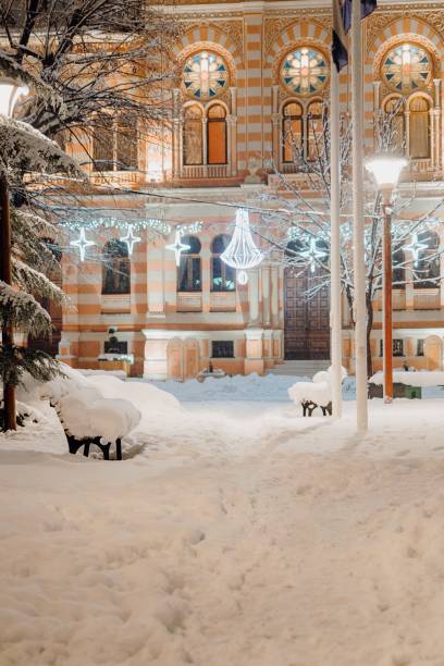 istock Snowy path to historic building with festive lights. 2191844629