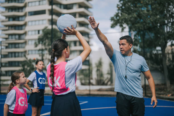 istock Australian coach guiding young netball female team players on routine practice 2191845105