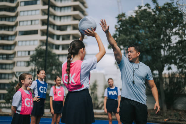 istock Australian coach guiding young netball female team players on routine practice 2191845107