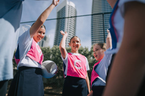 istock Australian young netball team players huddling stacking hands before the game start 2191845136
