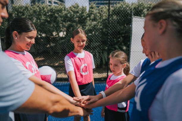 istock Australian young netball team players huddling stacking hands before the game start with coach 2191845140