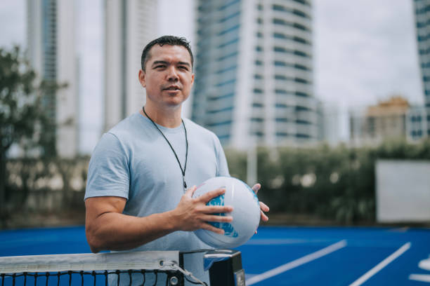istock Australian multiracial male coach with netball looking at camera smiling standing in front of sport court 2191845180