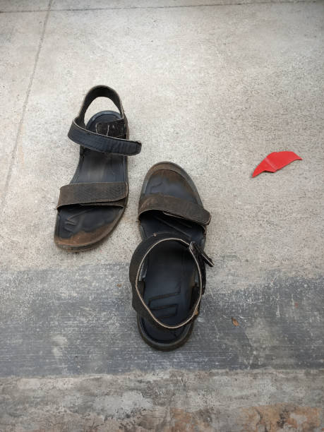 A Pair of old Men's Sandel on a cement concrete floor. Mysuru, Karnataka, India-December 25 2024; A Pair of old Men's Sandel on a cement concrete floor. sandel stock pictures, royalty-free photos & images