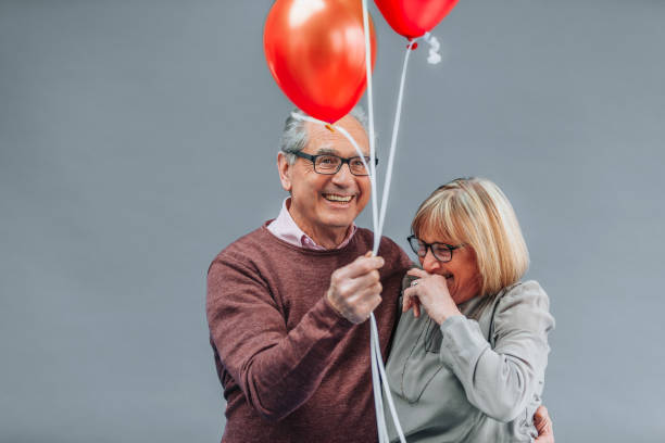 istock Joyful Senior Couple Celebrating with Red Balloons 2191848256