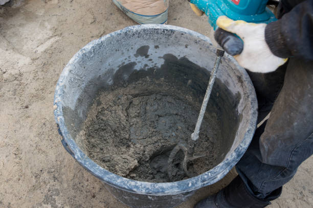 istock Mixing concrete in a bucket using a handheld concrete mixer. 2191852228