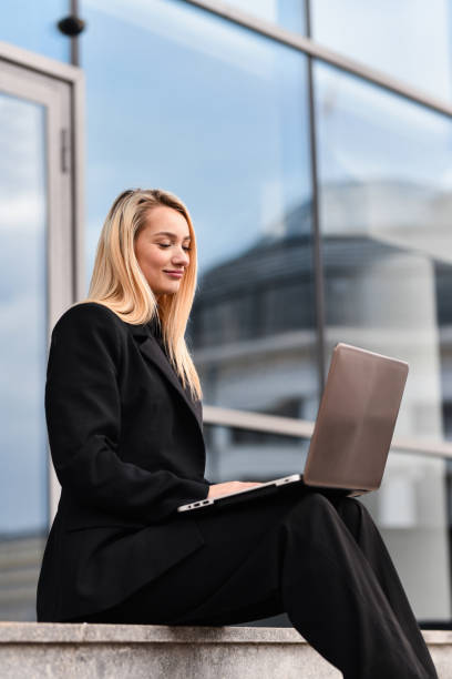 istock Beautiful Entrepreneur Responding to Emails While Sitting on Outdoors Stairs With Laptop 2191853583