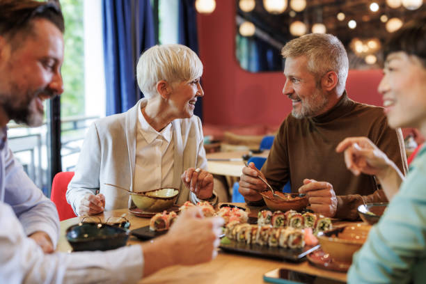 Four colleagues in a modern restaurant enjoy sushi