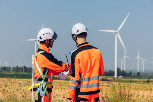 istock Survey Team Alternative energy for future. Engineers survey and checking wind turbines in sunset. Wind Turbine Renewable energy technology and sustainability. 2191857635