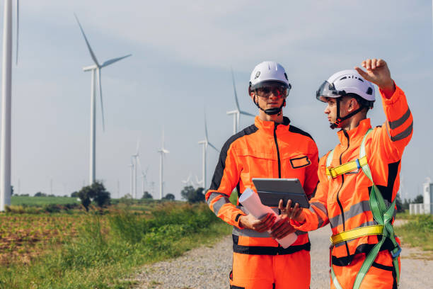 istock Survey Team Alternative energy for future. Engineers survey and checking wind turbines in sunset. Wind Turbine Renewable energy technology and sustainability. 2191857664