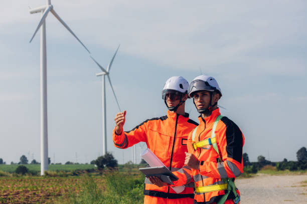 istock Survey Team Alternative energy for future. Engineers survey and checking wind turbines in sunset. Wind Turbine Renewable energy technology and sustainability. 2191857668