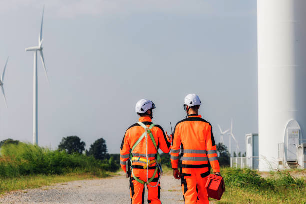 istock Survey Team Alternative energy for future. Engineers survey and checking wind turbines in sunset. Wind Turbine Renewable energy technology and sustainability. 2191857765