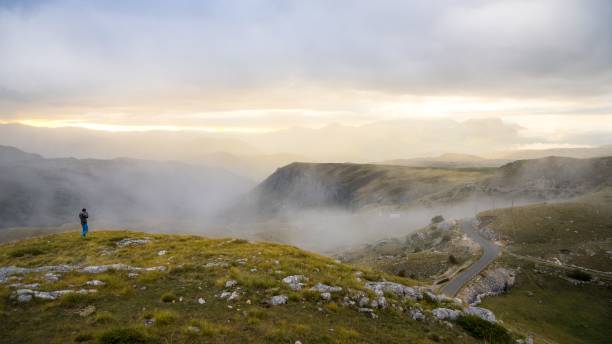 istock Hiker on misty mountain ridge at sunrise. 2191858131