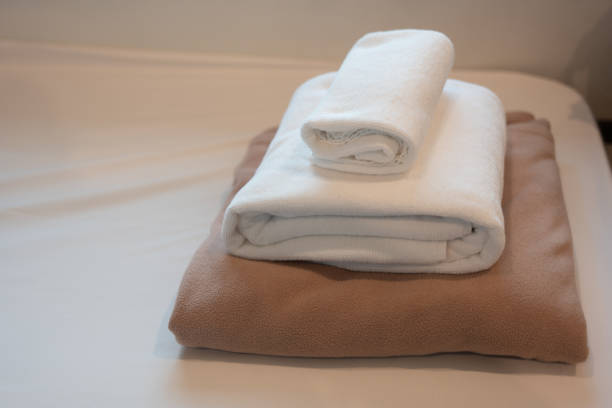 istock White fresh towels on bed in hotel room. 2191859583