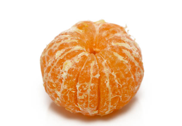 Minimal overhead shot of a whole mandarin on a clean light surface. Simple natural composition with soft daylight.