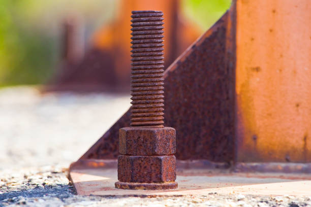 Weathered and decaying metal framework with rust-encrusted bolts and nuts - Old rusty iron structure with bolted metal profiles.