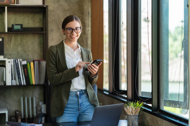istock Smiling businesswoman using a phone in the office. 2191861622