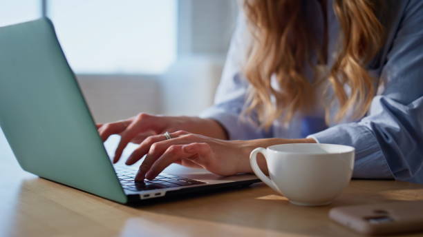 istock Closeup hands typing laptop keyboard on kitchen countertop. Remote woman working 2191863762