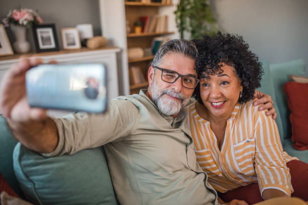 istock A middle-aged man winks while taking a selfie photo with his multiracial wife 2191865315