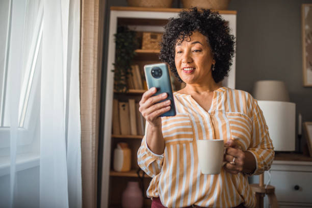 istock Carefree multiracial woman using smartphone to surf the internet while drinking coffee and relaxing at home 2191866900