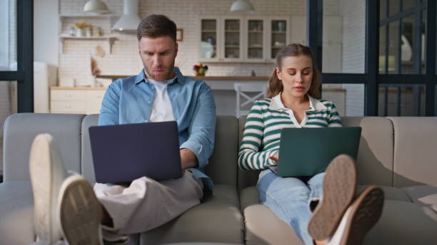 istock Involved freelancers working computers at sofa together. Focused husband wife 2191867171