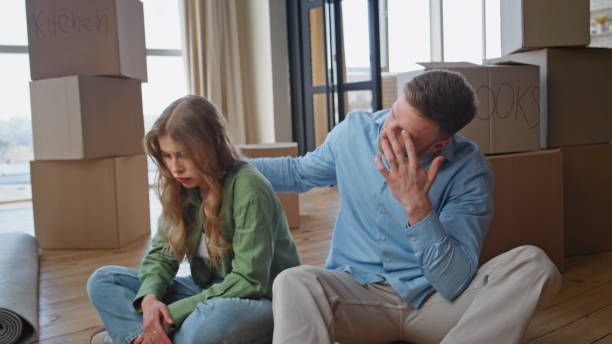 istock Couple rest moving house. Exhausted spouses sitting on floor surrounded boxes 2191867274