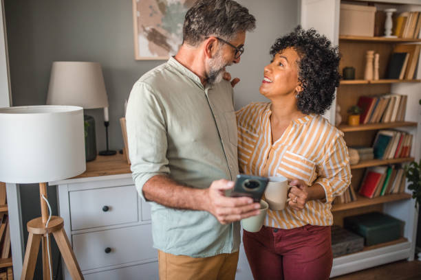 istock Multiracial loving couple looking at each other in love while drinking coffee 2191867580