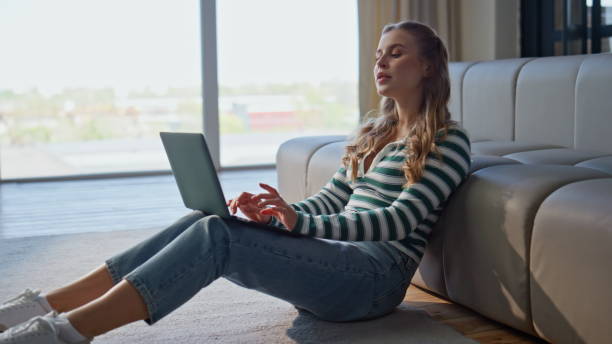 istock Pensive author working laptop in modern apartment. Serious woman typing computer 2191867849